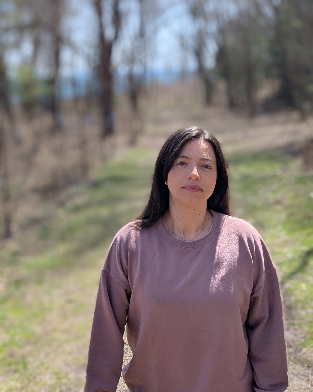 Portrait of Victoria Chavarro on a wooded trail beside the lake